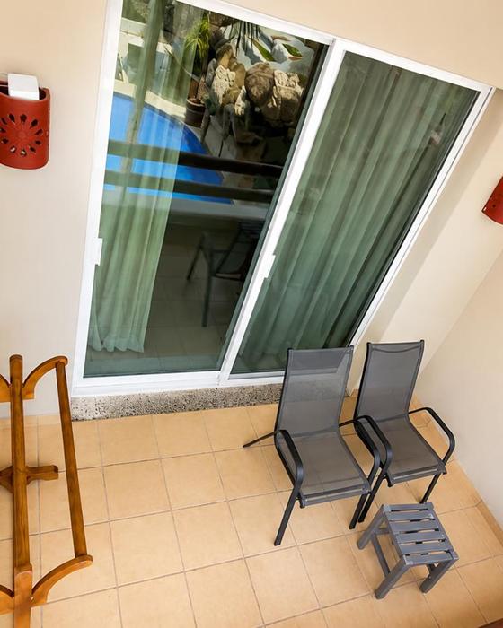 Balcony with two chairs and a glass door