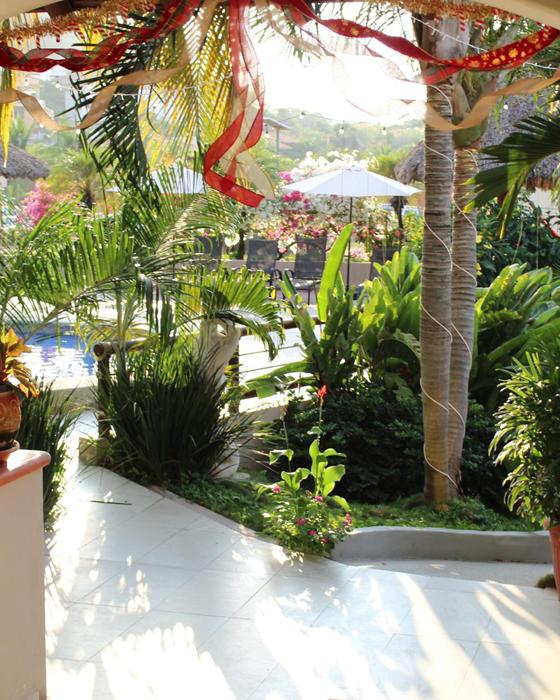 View through an arch to Hotel Bonito's garden and palm trees
