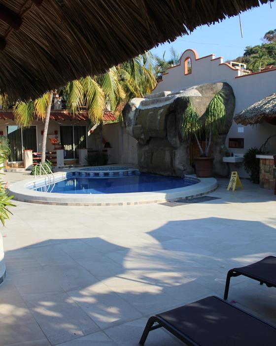View from the palapa to the pool, the waterfall and loungers