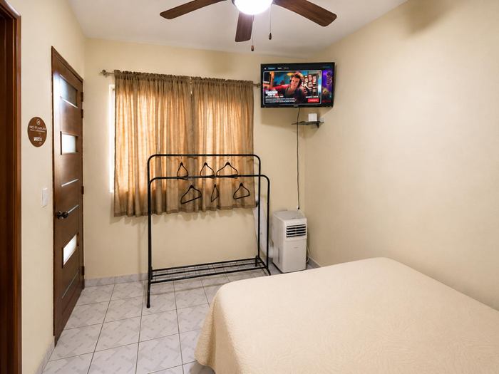 Single Room with TV, ceiling fan and clothes rack